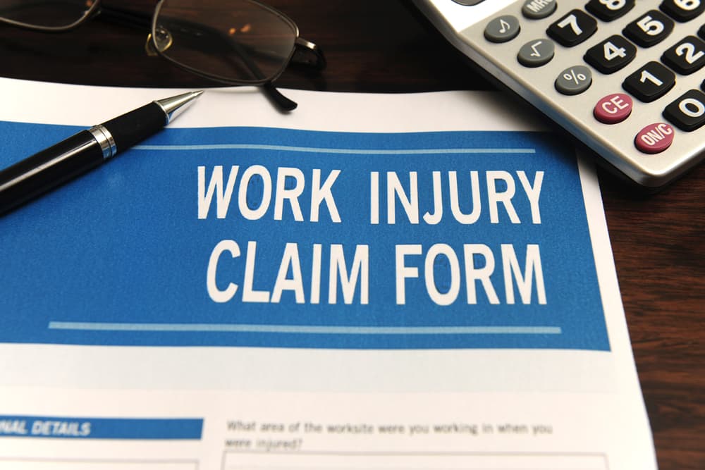 A blank work injury claim form is placed on a desk, ready for completion. 