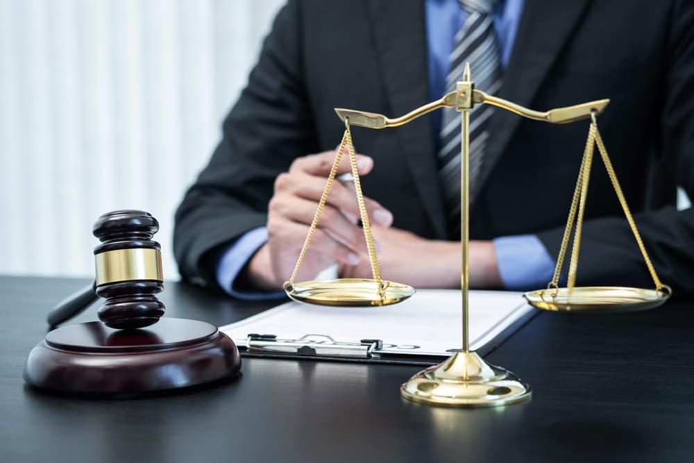 A male attorney reviewing a legal contract and case documents in his office.