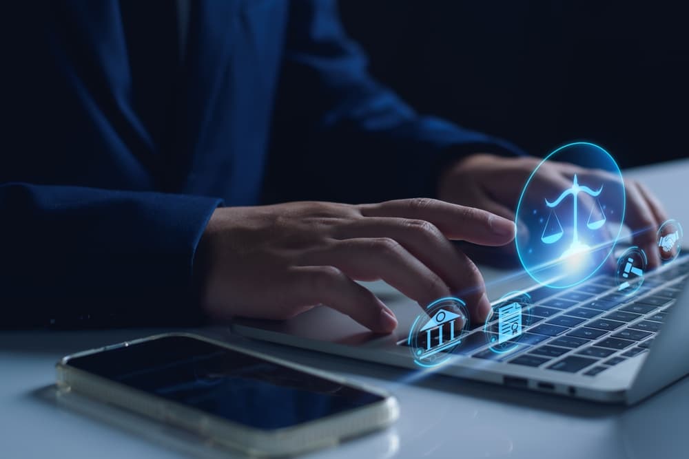 person at computer with scales of justice illuminated