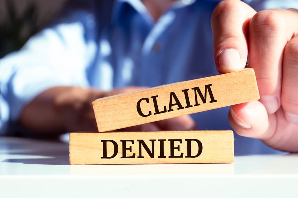 Wooden blocks with words 'Claim denied'.